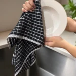 Midnight Black Grid Terry Tea Towel being used to dry a white plate.