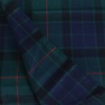 Close up view of soft navy and green cotton flannel plaid fabric with red overcheck